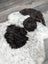 A large soft spotted icelandic sheepskin rug with natural white wool and two dark black patches of fur