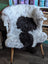A cozy plush 41 x 31 inch large spotted icelandic sheepskin chair cover with black and white cow print pattern