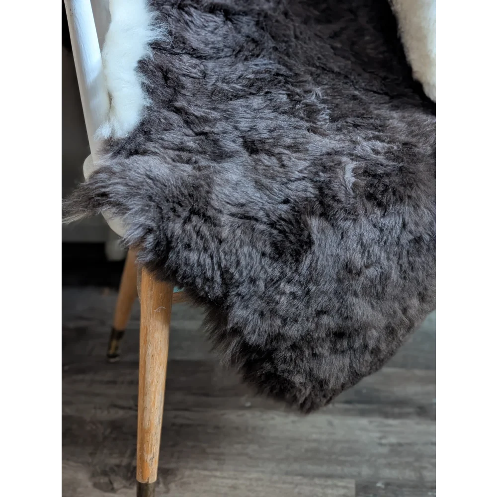 A plush large dark gray icelandic sheepskin rug with soft short wool and natural fluffy fur pile