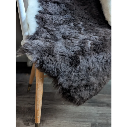 A plush large dark gray icelandic sheepskin rug with soft short wool and natural fluffy fur pile