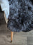 A plush dark gray icelandic sheepskin throw with short wool draped over a white chair with wooden legs