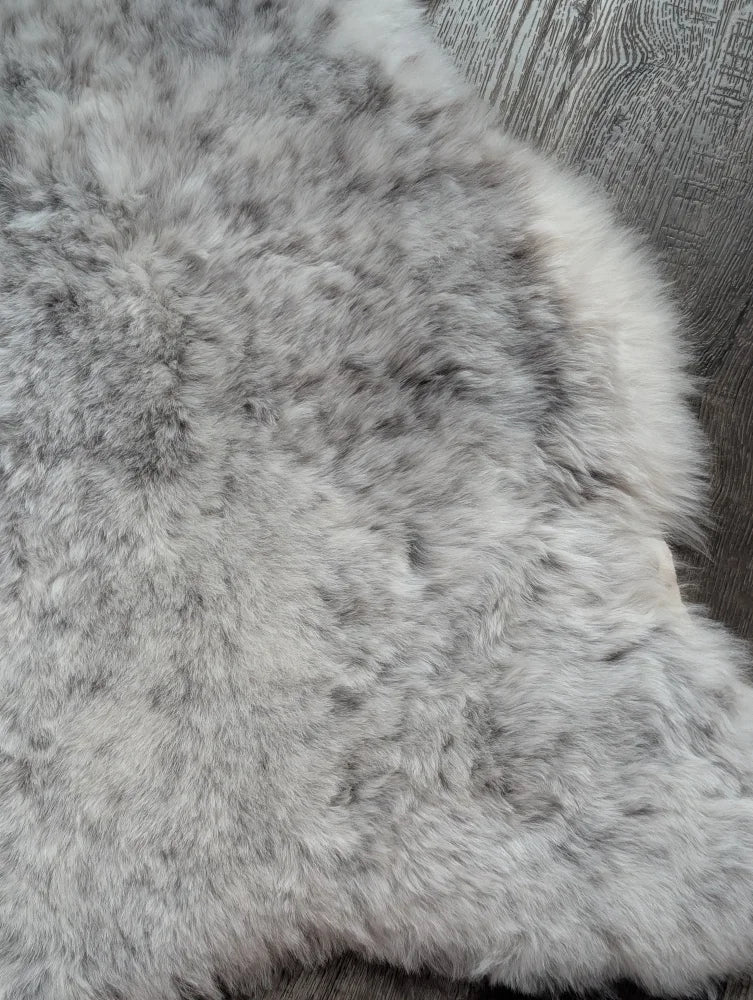 A plush gray large soft spotted icelandic sheepskin rug with natural texture and medium spotted icelandic wool