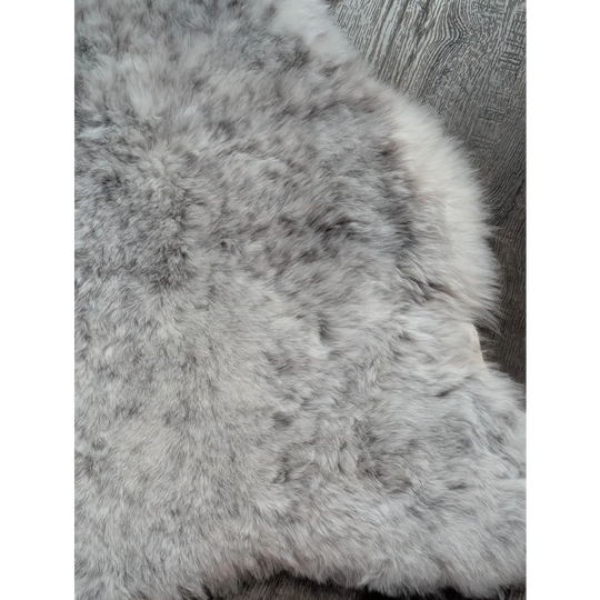 A plush gray large soft spotted icelandic sheepskin rug with natural texture and medium spotted icelandic wool