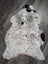 A large soft spotted icelandic sheepskin rug with natural white and black wool texture perfect for cozy spaces