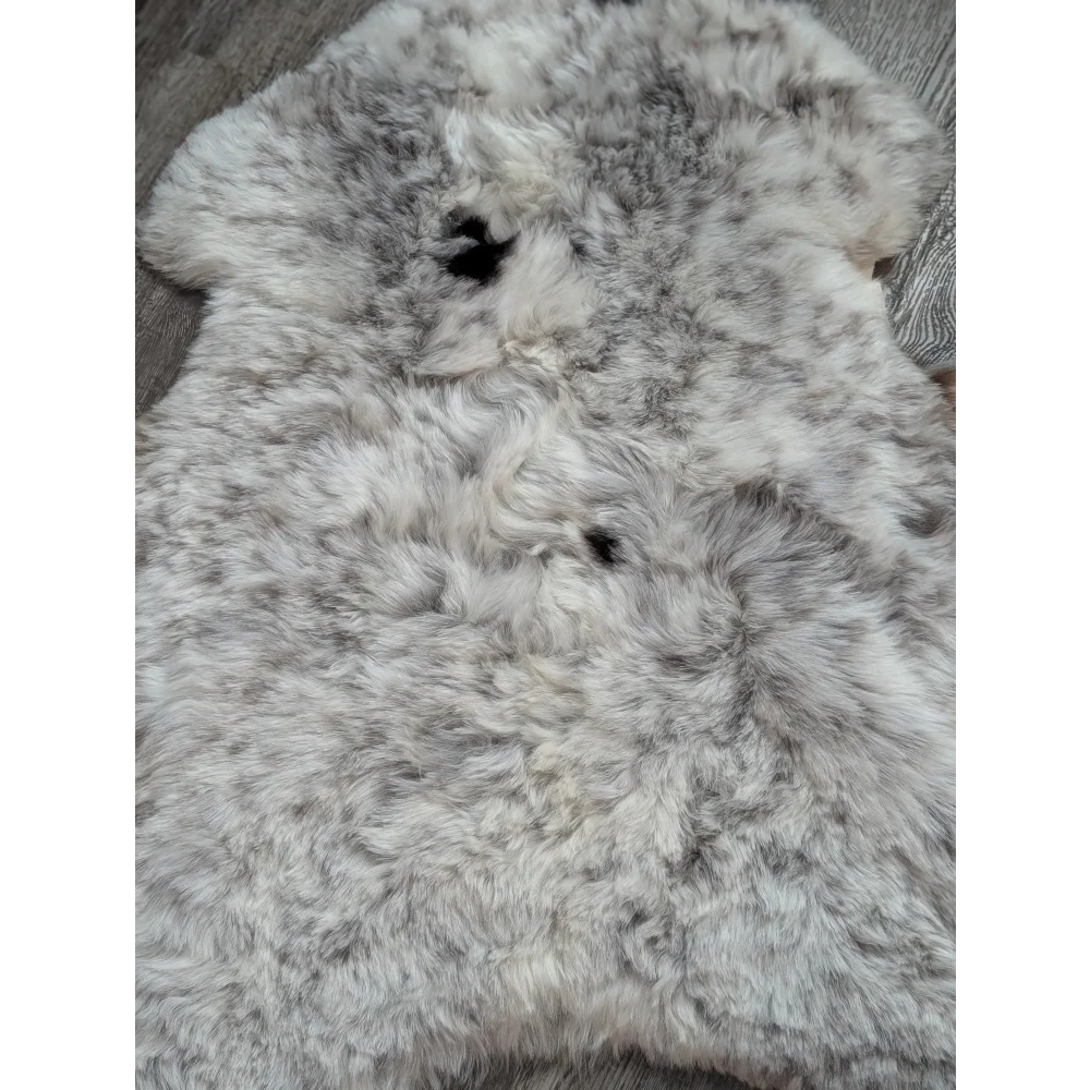 A plush spotted Icelandic sheepskin rug with soft white and gray wool in a large 42 by 29 inch size