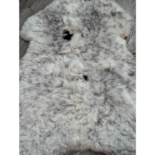 A plush spotted Icelandic sheepskin rug with soft white and gray wool in a large 42 by 29 inch size