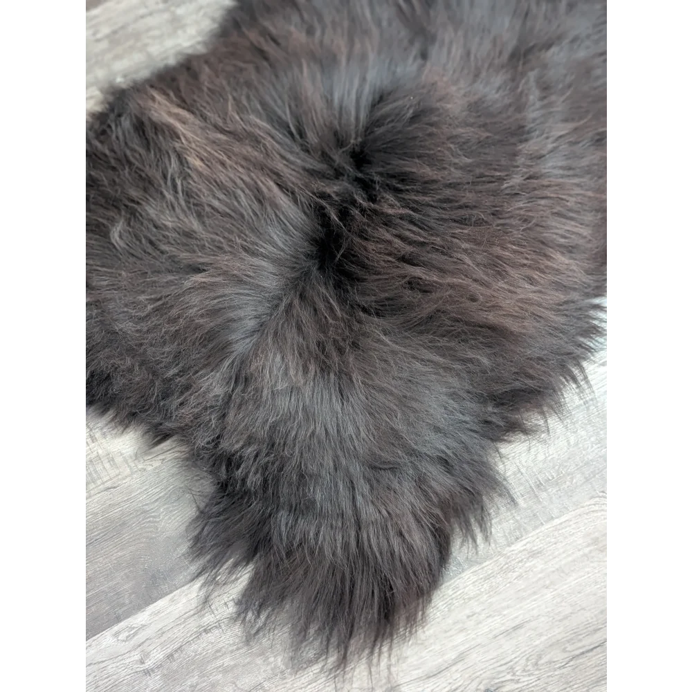 A large soft icelandic sheepskin rug in dark gray with long wool and natural-looking dense pile ideal for cozy spaces
