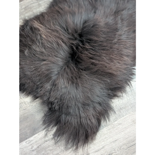 A large soft icelandic sheepskin rug in dark gray with long wool and natural-looking dense pile ideal for cozy spaces