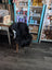 A large soft black icelandic sheepskin throw with long wool draped over a white wooden chair with light brown legs