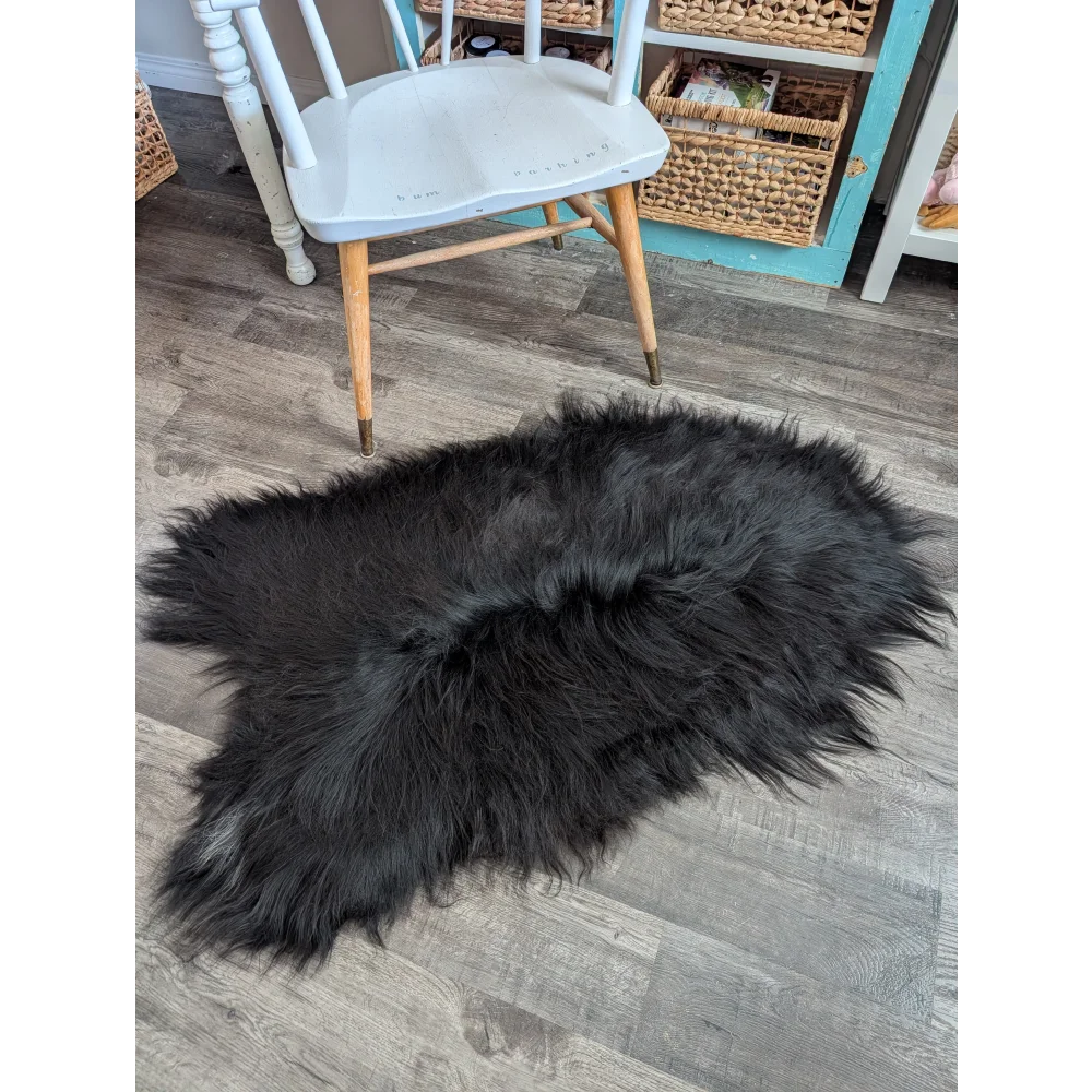 Black fluffy long wool icelandic sheepskin rug with natural irregular shape and dense soft wool icelandic fur