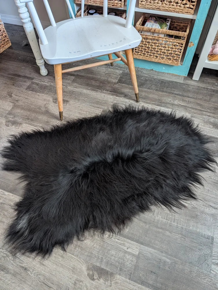 Black fluffy long wool icelandic sheepskin rug with natural irregular shape and dense soft wool icelandic fur