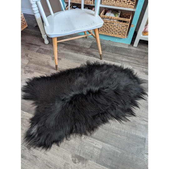Black fluffy long wool icelandic sheepskin rug with natural irregular shape and dense soft wool icelandic fur