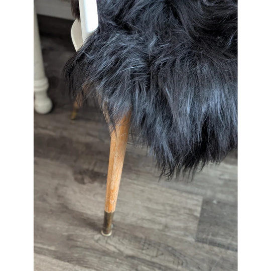 Large luv34 black faux fur chair with wooden legs and brass feet featuring soft wool icelandic sheepskin cover