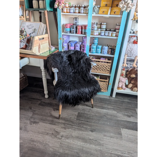 Black fluffy icelandic sheepskin chair with light wooden legs featuring long wool icelandic softness