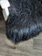 Black faux fur chair cover with plush shaggy texture made of soft wool icelandic long wool sheepskin