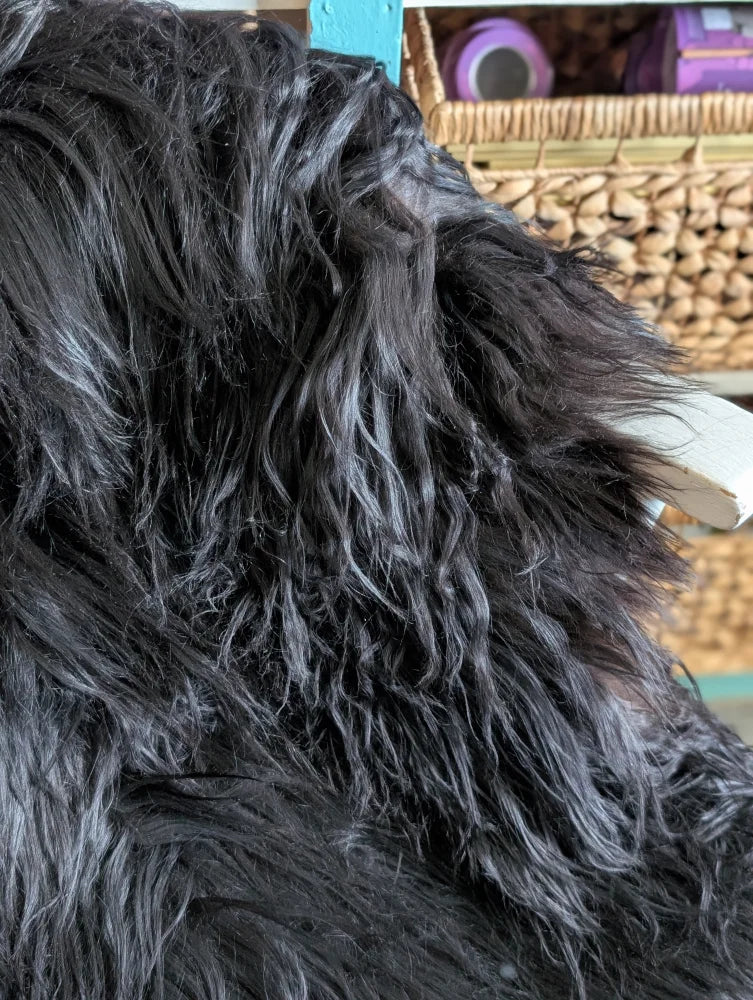 A large soft icelandic sheepskin throw in natural black with long wool and plush textured surface ideal for cozy use