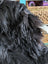 A large soft icelandic sheepskin throw in natural black with long wool and plush textured surface ideal for cozy use