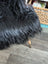 Black faux fur chair with plush shaggy texture and wooden legs made from long wool icelandic sheepskin