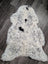 A plush spotted icelandic sheepskin rug with soft white wool and medium black patches perfect for cozy decor