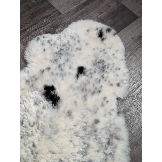 Large spotted icelandic sheepskin rug with creamy white base and black spots made of soft short wool