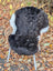 Luv40 black and white wool icelandic sheepskin with fluffy texture and dark edges draped over a wicker chair