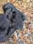 A plush dark gray wool icelandic sheepskin dog toy with soft textured surface and subtle dark edges