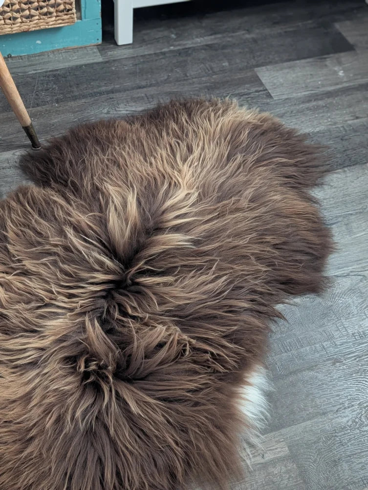 A plush heart-shaped brown icelandic sheepskin rug with long wool icelandic texture and subtle tan highlights