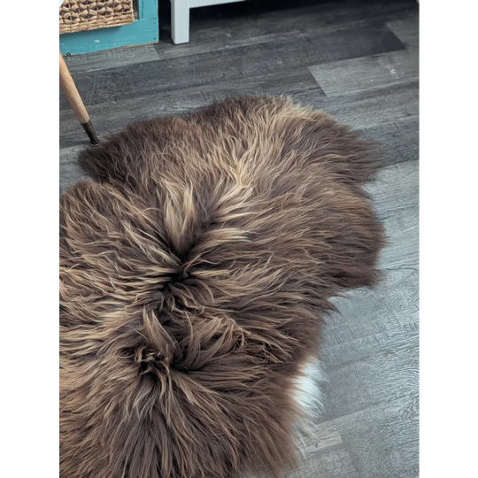 A plush heart-shaped brown icelandic sheepskin rug with long wool icelandic texture and subtle tan highlights