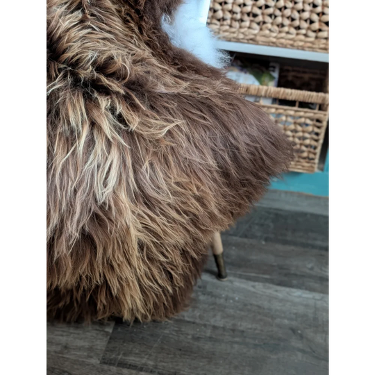 A plush shaggy brown and cream faux wool icelandic sheepskin throw blanket with soft long wool icelandic texture