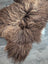 A plush 55 x 33 inch long wool icelandic sheepskin rug in bronze with soft shaggy fur and tan highlights