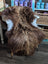 A plush long wool icelandic sheepskin rug in bronze draped over a white wooden chair for cozy decor