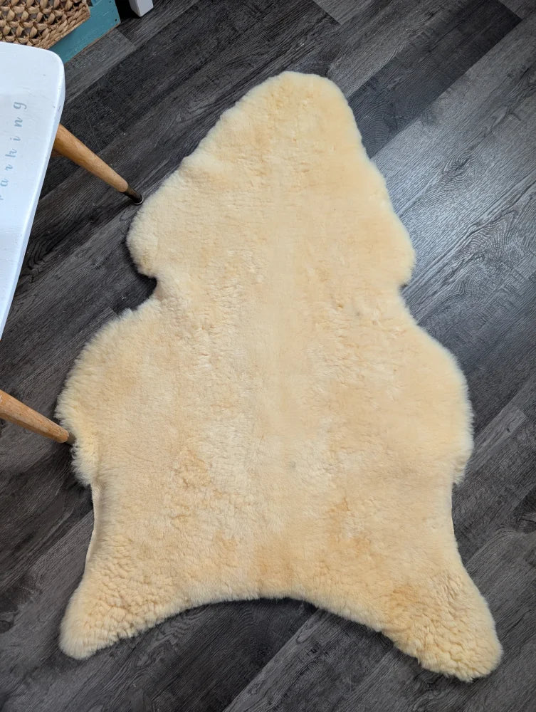 Cream-colored medical sheepskin rug with fluffy texture and irregular shape from angus oliver washable sheepskin rugs