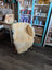 Cream-colored medical sheepskin washable chair cover draped over wooden armchair from angus oliver sheepskin rugs