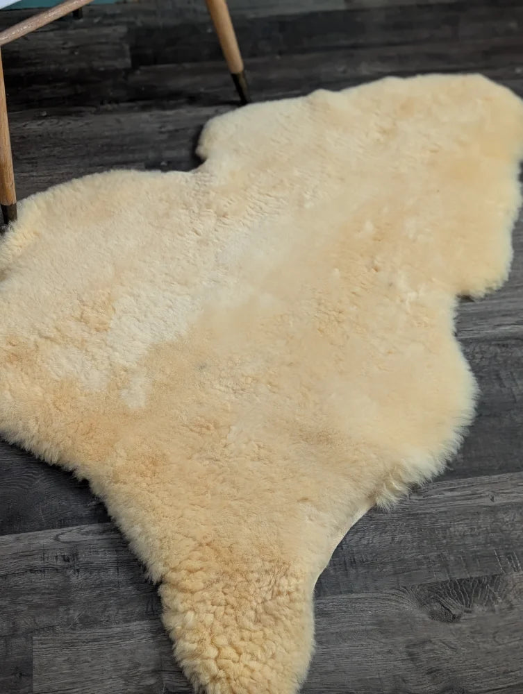 Cream-colored medical sheepskin rug with soft fluffy texture and natural shape by angus oliver, washable and massive