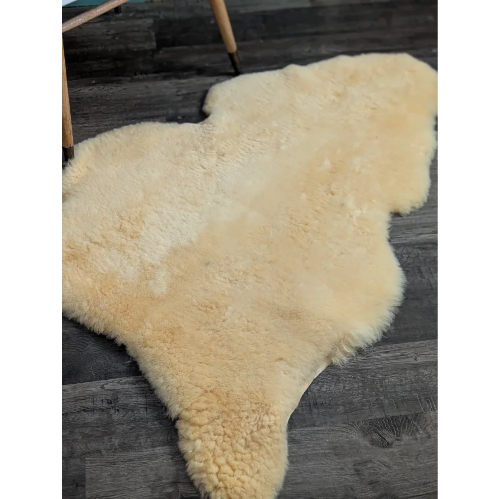 Cream-colored medical sheepskin rug with soft fluffy texture and natural shape by angus oliver, washable and massive