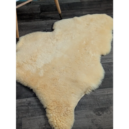 Cream-colored medical sheepskin rug with soft fluffy texture and natural shape by angus oliver, washable and massive