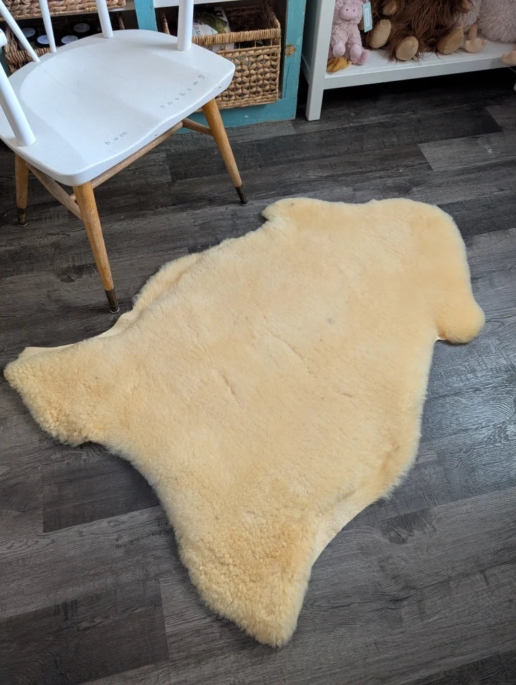 Cream-colored massive washable medical sheepskin rug with soft fluffy texture and natural edges by angus oliver