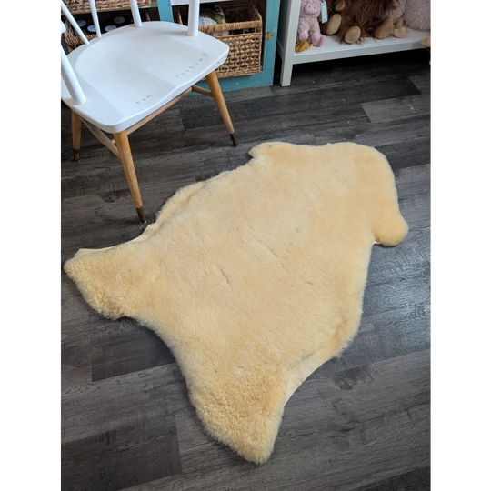 Cream-colored massive washable medical sheepskin rug with soft fluffy texture and natural edges by angus oliver