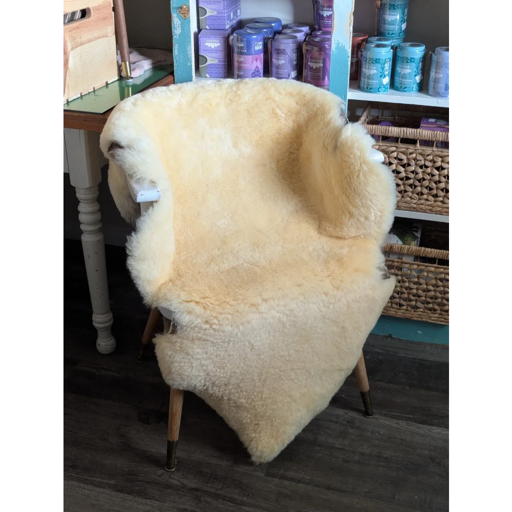Cream-colored angus oliver medical sheepskin chair with wooden legs perfect for washable sheepskin rugs and cowhide rugs