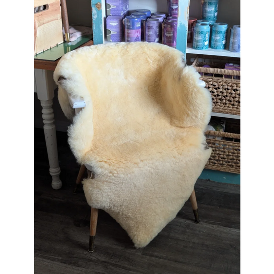 Cream-colored angus oliver medical sheepskin chair with wooden legs perfect for washable sheepskin rugs and cowhide rugs