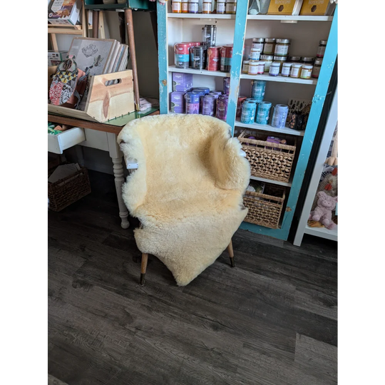 Cream-colored washable medical sheepskin chair with wooden legs by angus oliver for comfort and style