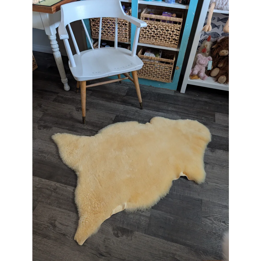 Cream-colored medical sheepskin rug with soft fluffy texture and natural edges by angus oliver, perfect for sheepskin rugs and cowhide rugs fans