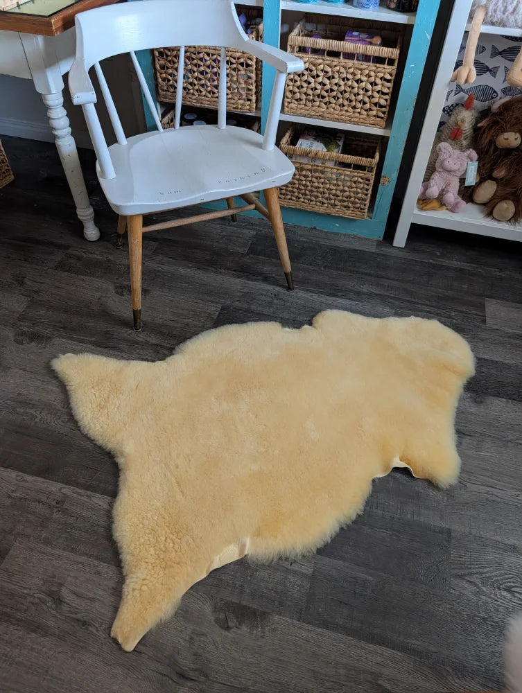 Cream-colored medical sheepskin rug with soft fluffy texture and natural edges by angus oliver, perfect for sheepskin rugs and cowhide rugs fans
