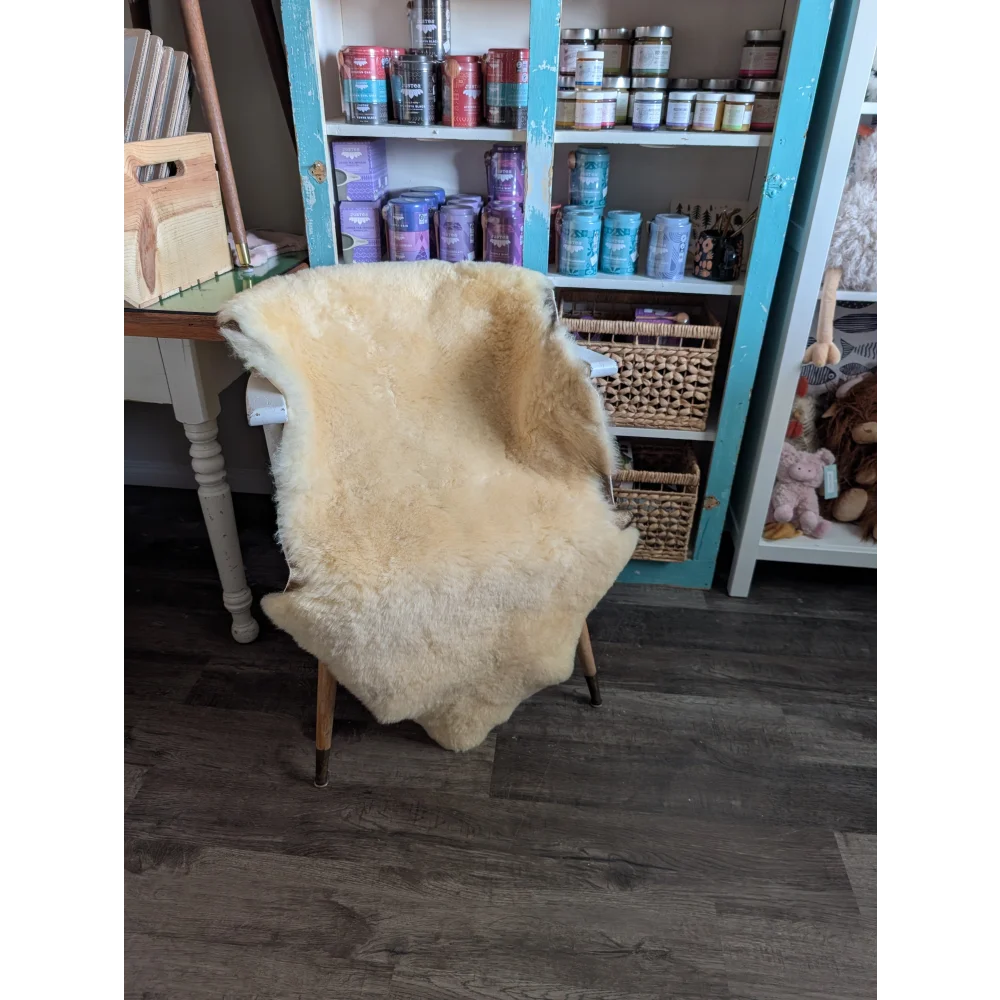 Cream-colored extra large washable medical sheepskin rug draped over chair by angus oliver