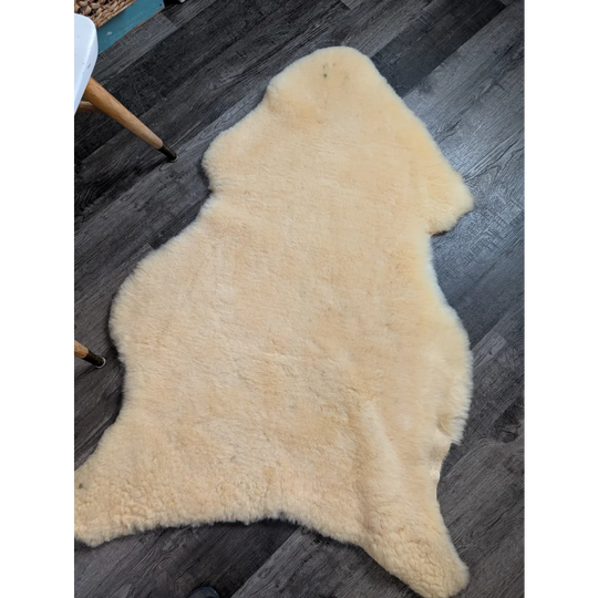 Cream-colored angus oliver massive washable medical sheepskin rug with soft fluffy texture and natural edges