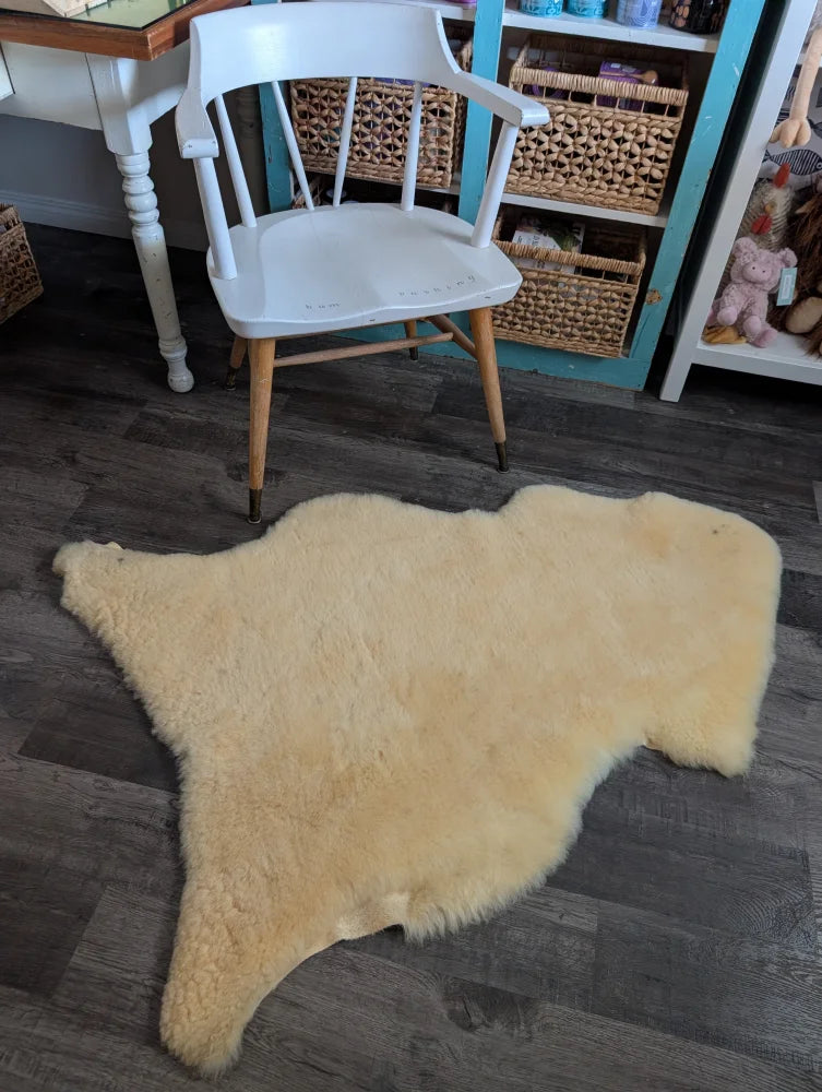 Cream-colored washable medical sheepskin rug with fluffy texture and natural edges by angus oliver for cozy use