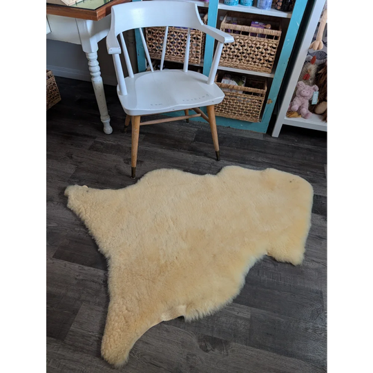 Cream-colored washable medical sheepskin rug with fluffy texture and natural edges by angus oliver for cozy use