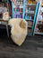 A cozy cream-colored medical sheepskin draped over a wooden frame from angus oliver sheepskin rugs and cowhide rugs