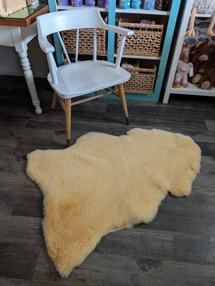 Cream-colored extra large washable medical sheepskin rug with natural fluffy texture and irregular edges by angus oliver