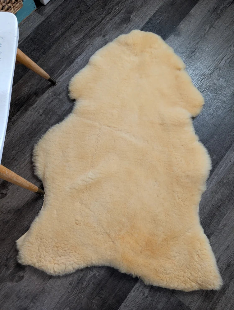 Cream-colored extra large angus oliver medical sheepskin rug with soft fluffy texture and natural irregular edges